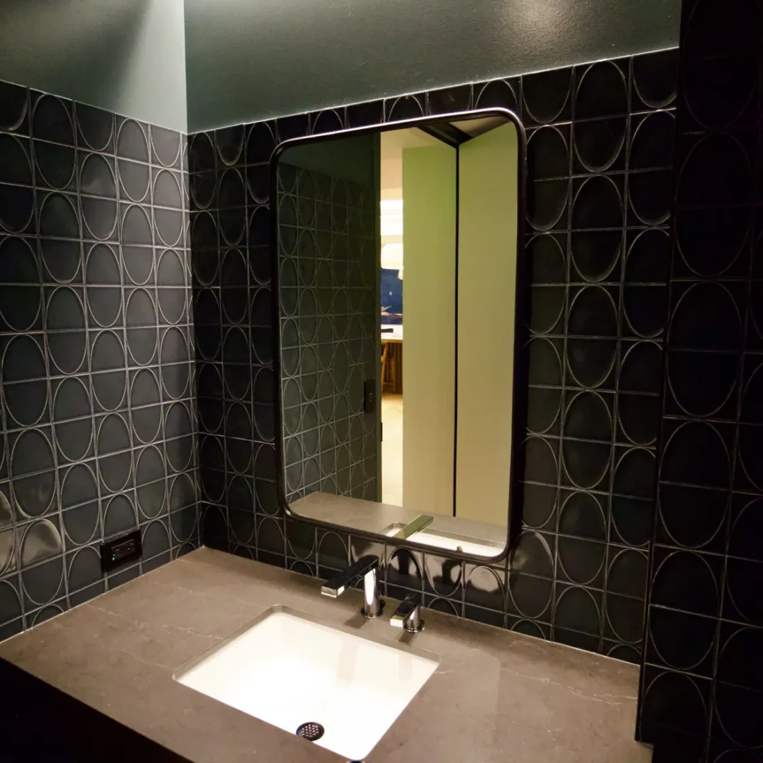Interior glazing at 1201 NW 3rd: black-framed glass doors, partitions and mirrors on the building amenity floor.