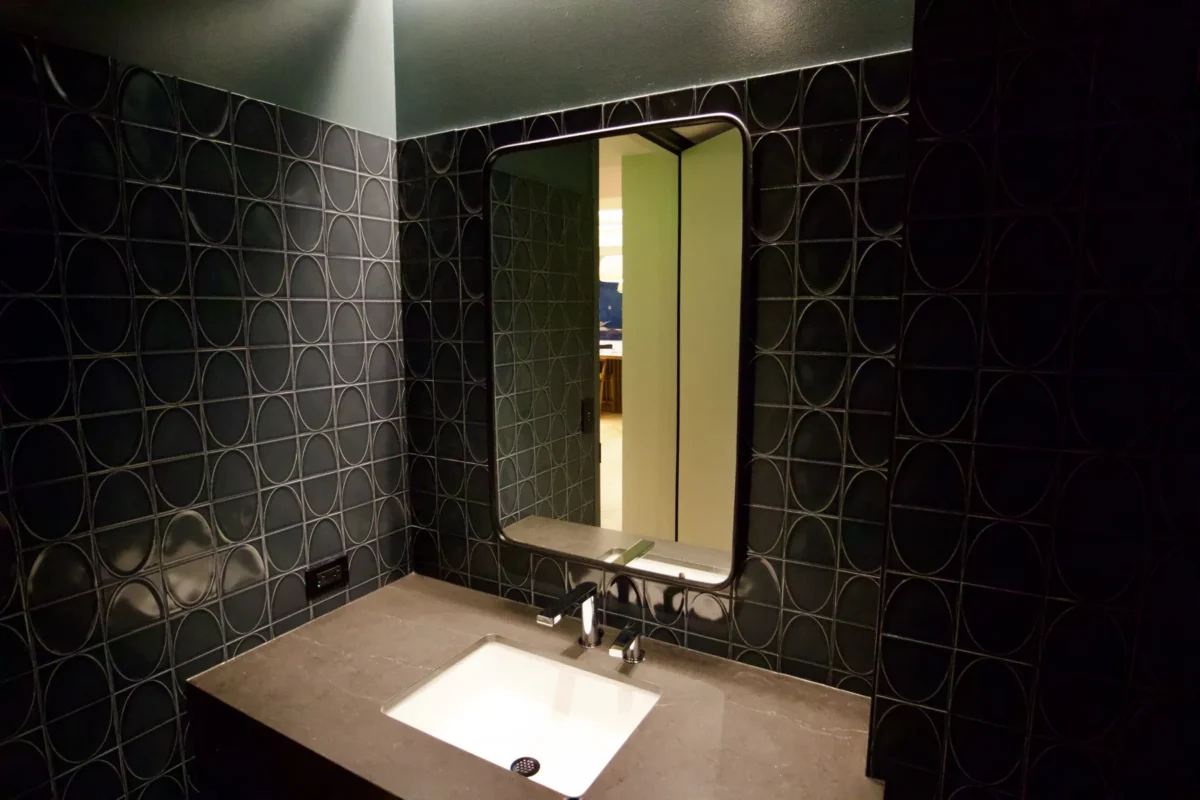 Interior glazing at 1201 NW 3rd: black-framed glass doors, partitions and mirrors on the building amenity floor.