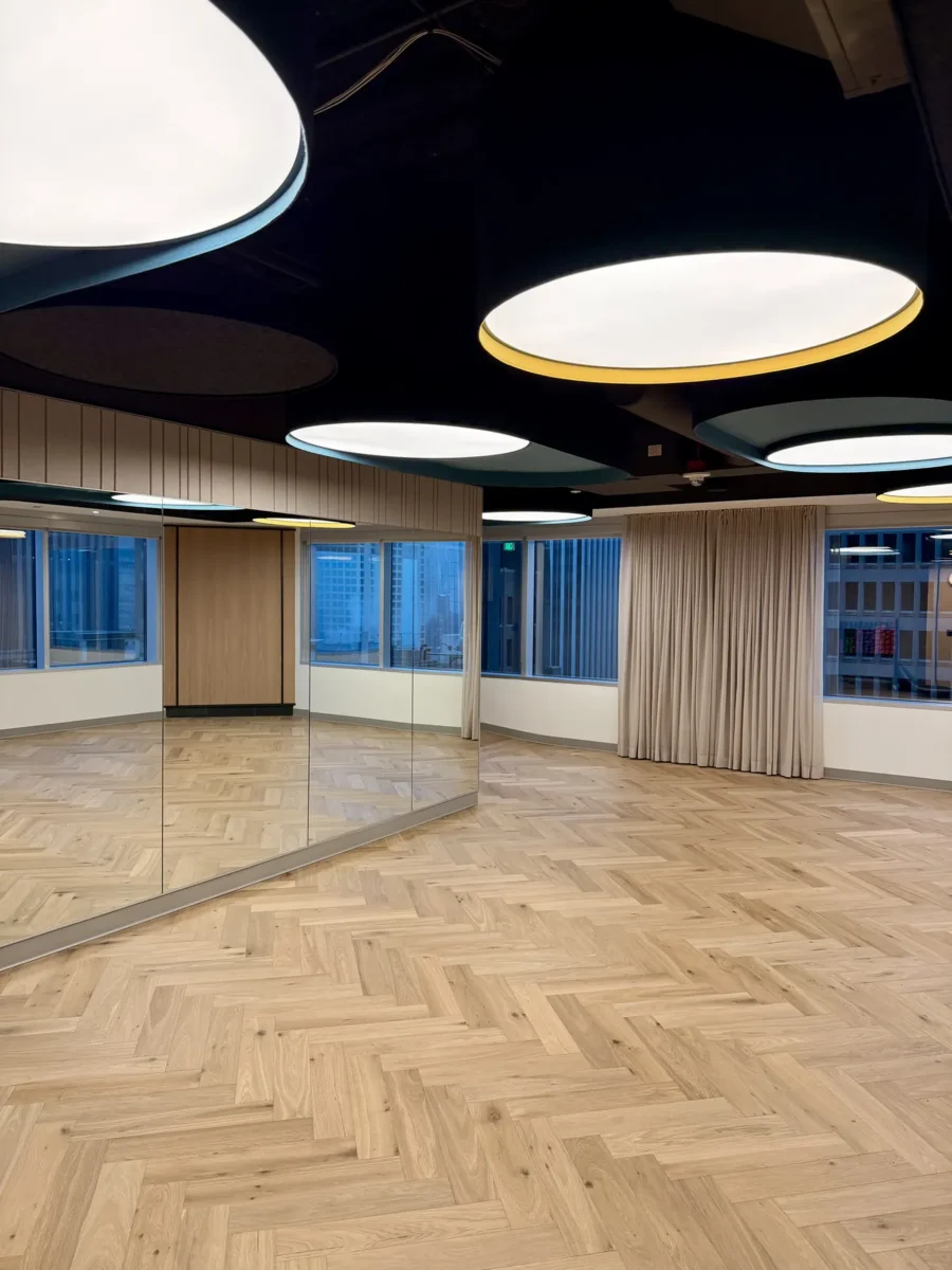 Interior glazing at 1201 NW 3rd: black-framed glass doors, partitions and mirrors on the building amenity floor.