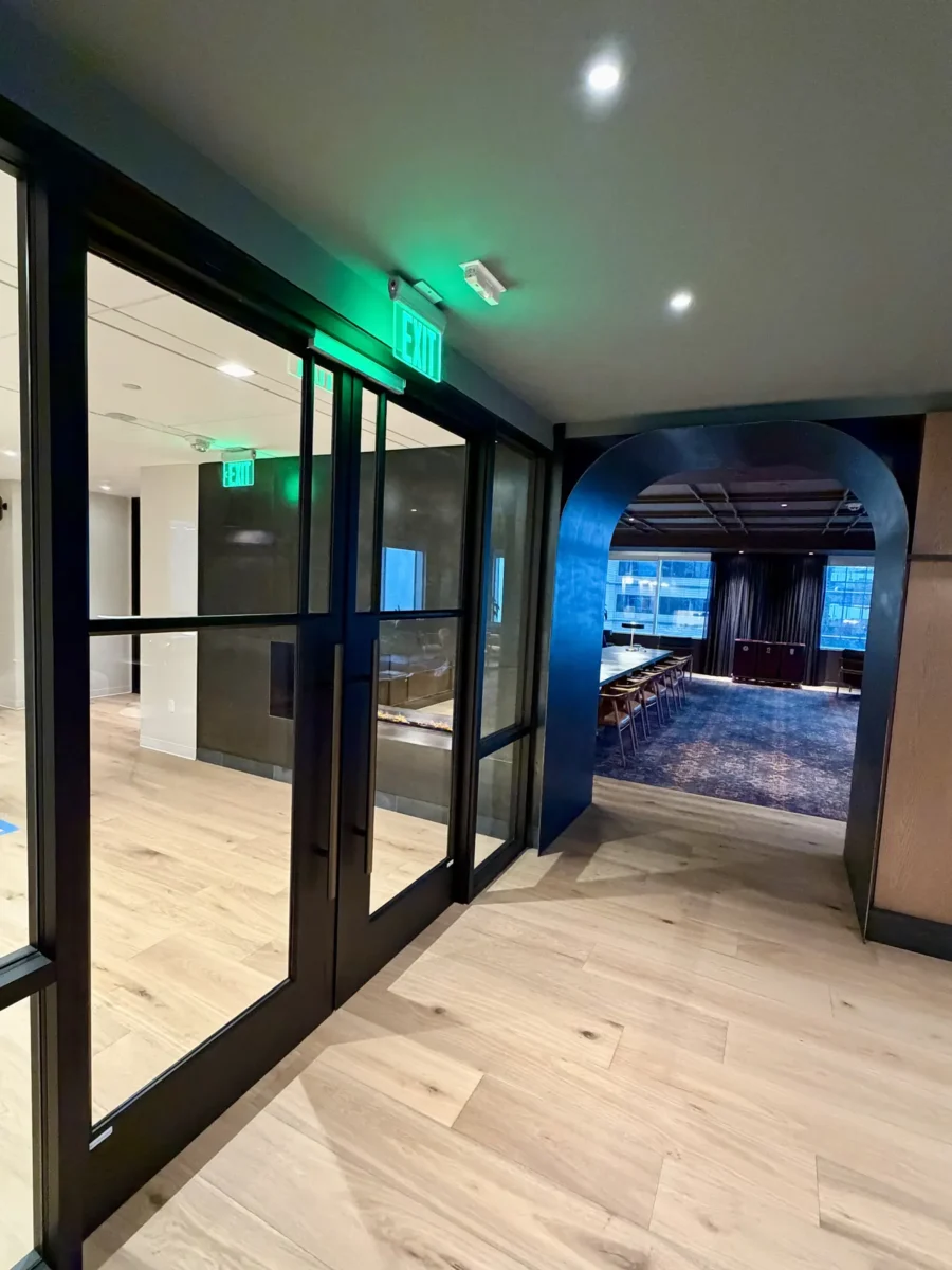 Interior glazing at 1201 NW 3rd: black-framed glass doors, partitions and mirrors on the building amenity floor.