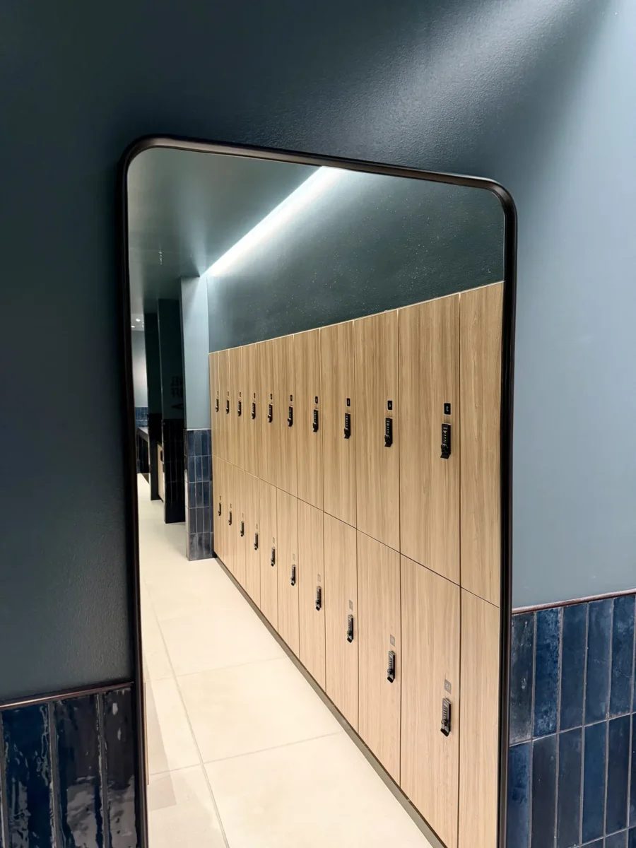 Interior glazing at 1201 NW 3rd: black-framed glass doors, partitions and mirrors on the building amenity floor.