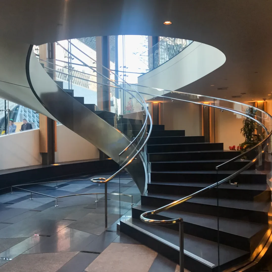 A curved glass stair rail in the lobby at 5th and Madison.