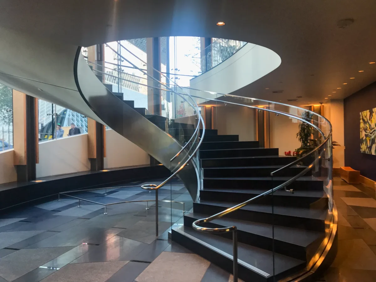A curved glass stair rail in the lobby at 5th and Madison.