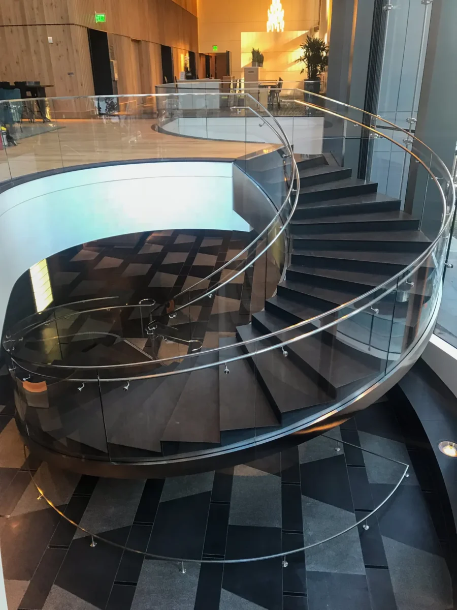 A curved glass stair rail in the lobby at 5th and Madison.
