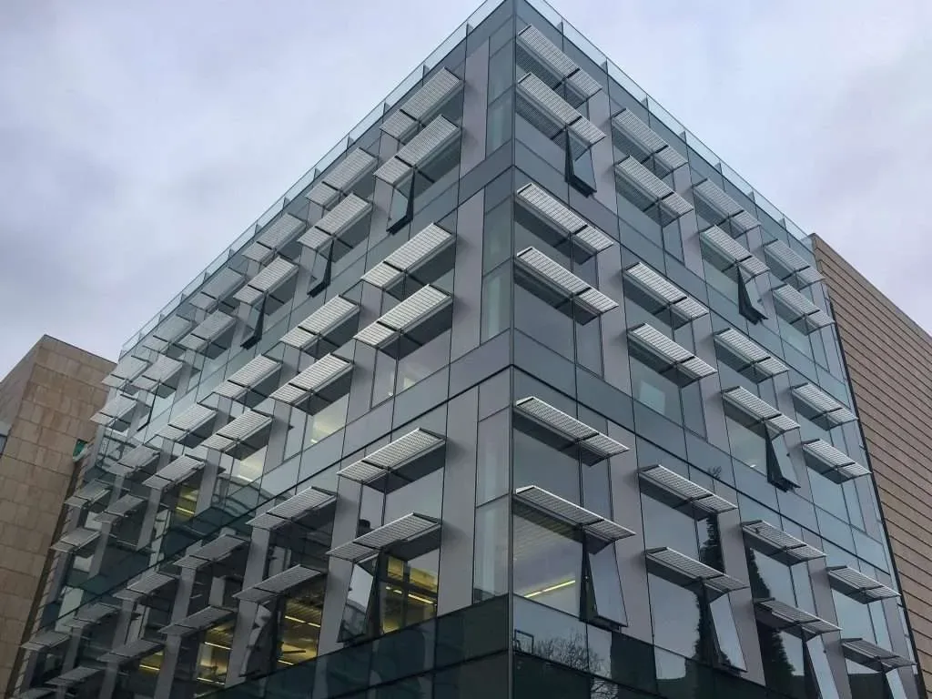 A multi-story building clad in Herzog Glass curtain wall and sunshades.