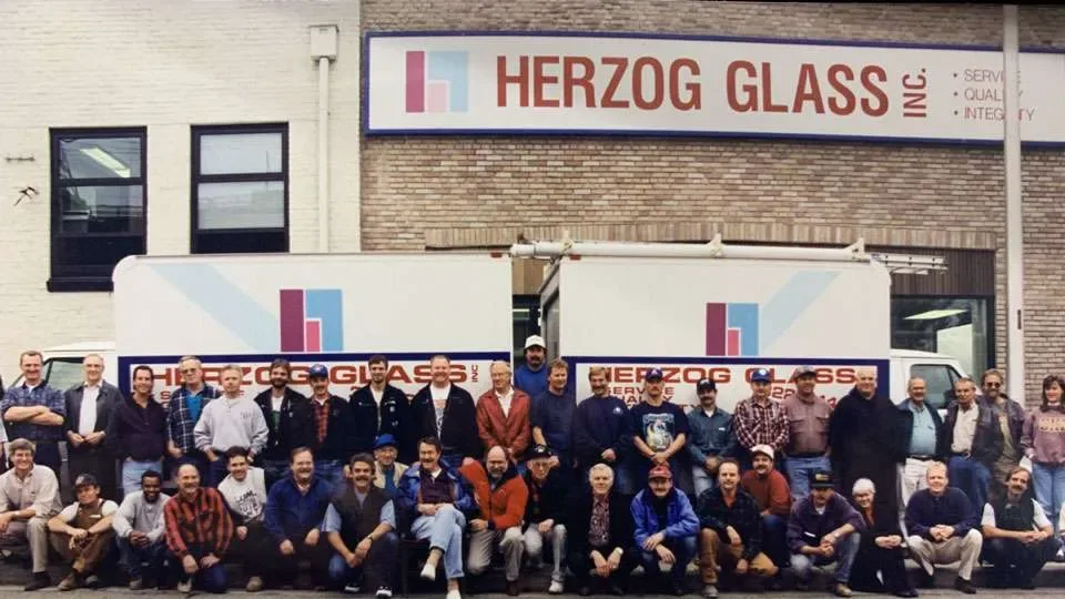 The Herzog Glass crew gathered outside the shop beneath the company sign.
