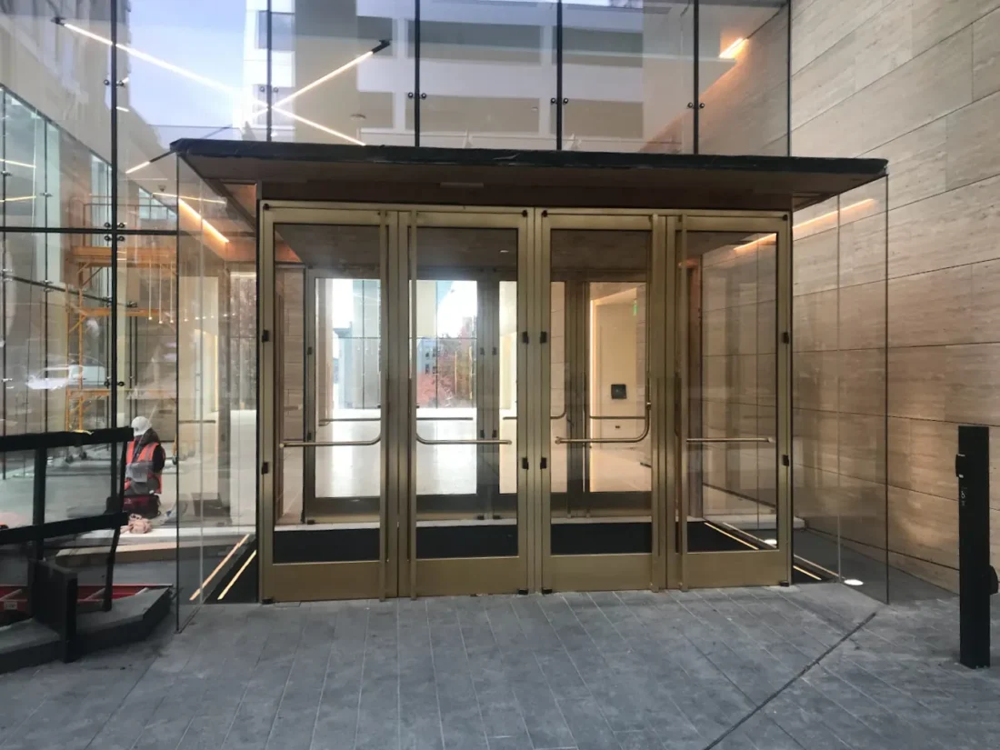A bronze-framed revolving door at the entrance to an office tower.