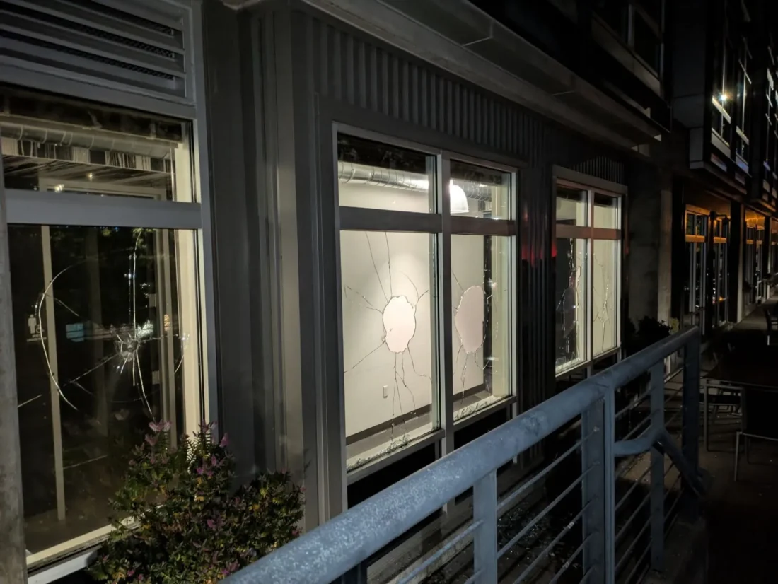 Cracked storefront glass on a commercial building at night