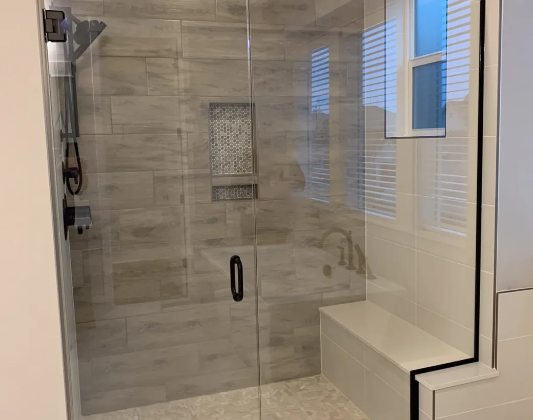Frameless glass shower enclosure with a tiled bench