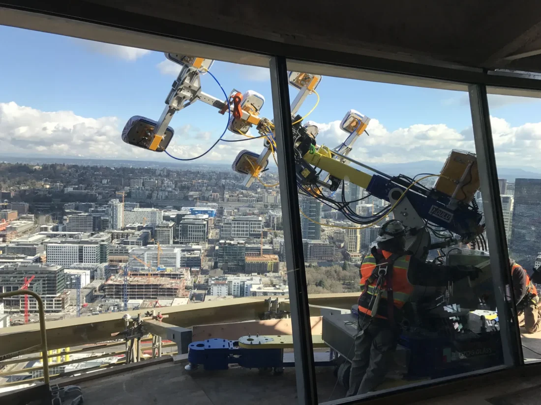 Robotic lifter setting a glass panel on the Space Needle