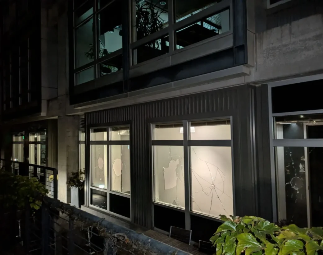 Damaged ground-floor glass on a commercial building at night