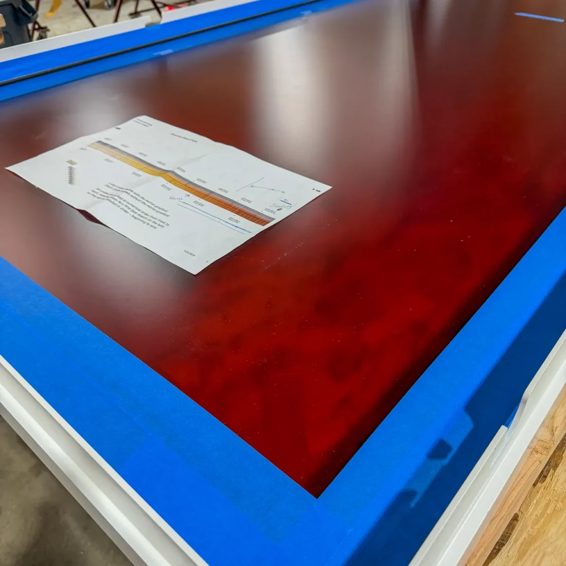 Aluminum and glass canopy assemblies and their shop drawings on the fabrication floor.