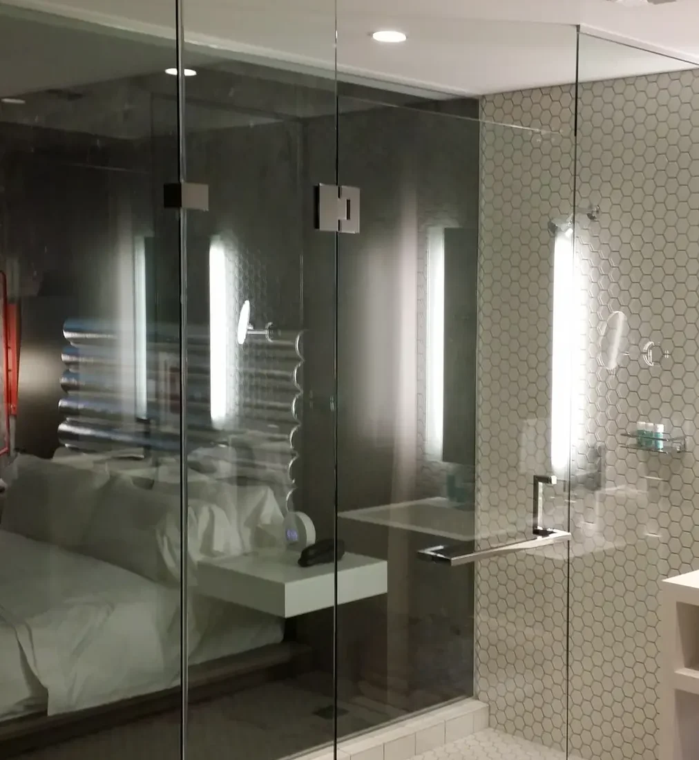 A frameless glass shower enclosure in a tiled bathroom.