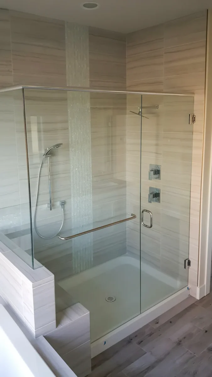 A frameless glass shower enclosure in a tiled bathroom.