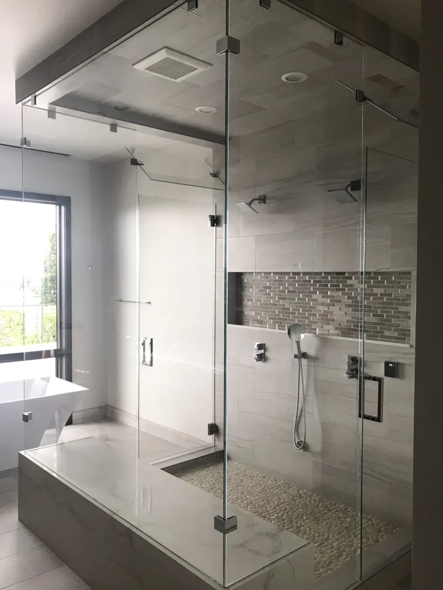 A frameless glass shower enclosure in a tiled bathroom.
