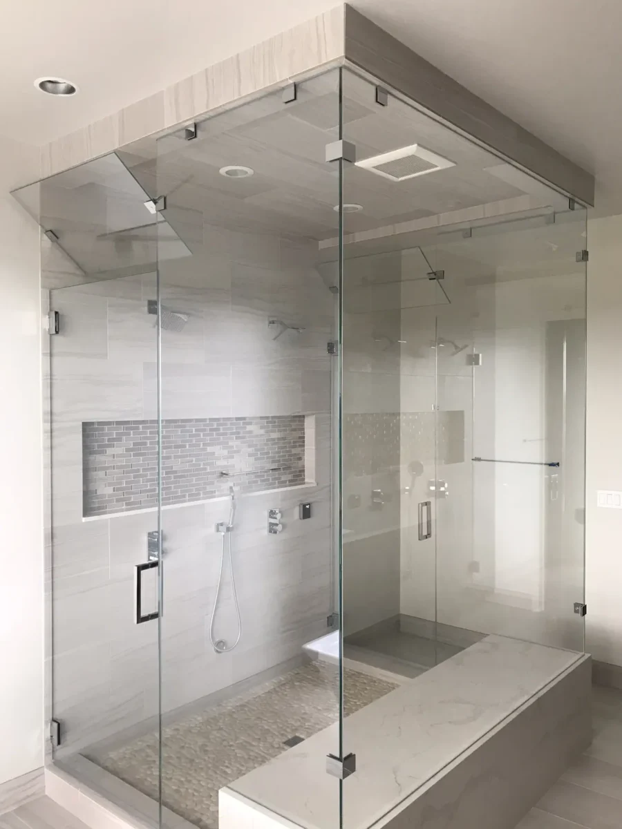 A frameless glass shower enclosure in a tiled bathroom.