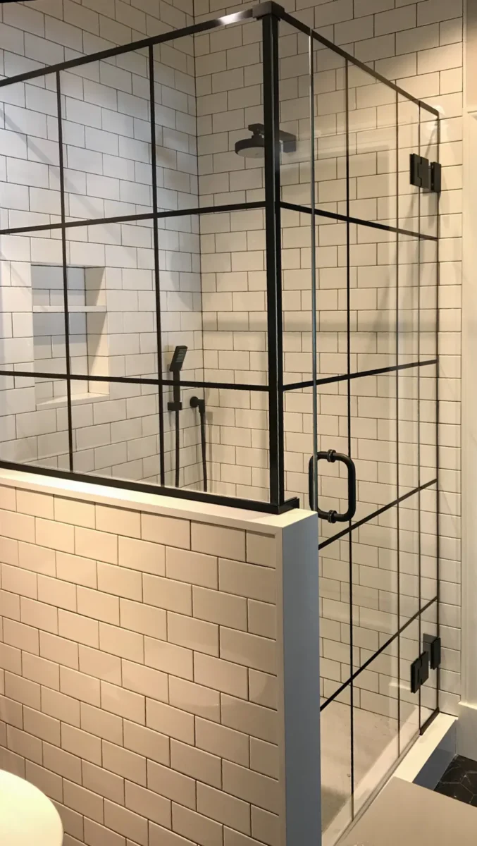 A frameless glass shower enclosure in a tiled bathroom.