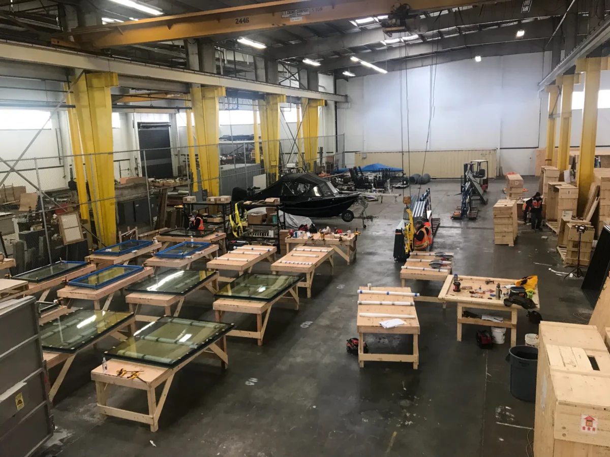 Space Needle glass staged on tables and in crates across the Herzog Glass shop floor