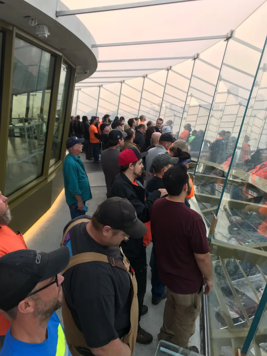 Visitors and crew on the observation deck at the edge of the new glass