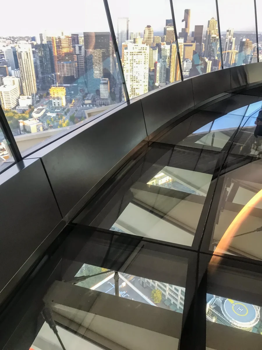 Looking down at the city through the tilted observation deck glass