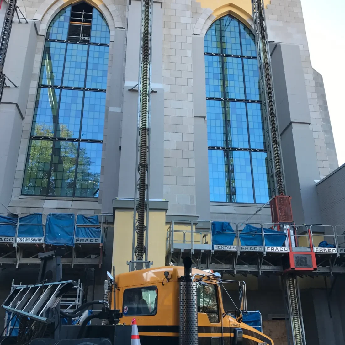 Colored glass panels in the arched windows of St Mark’s Cathedral, and the same panels on the shop floor before installation.