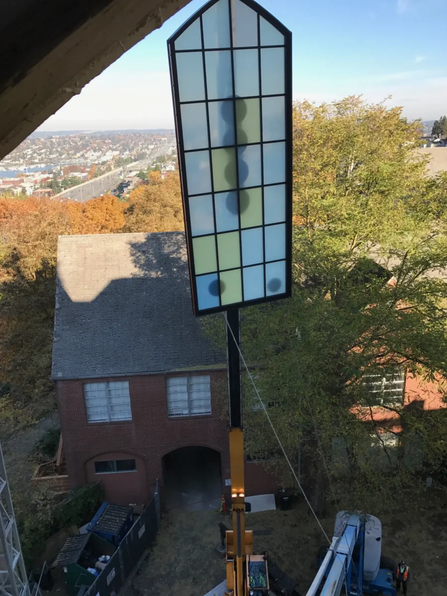 Colored glass panels in the arched windows of St Mark’s Cathedral, and the same panels on the shop floor before installation.