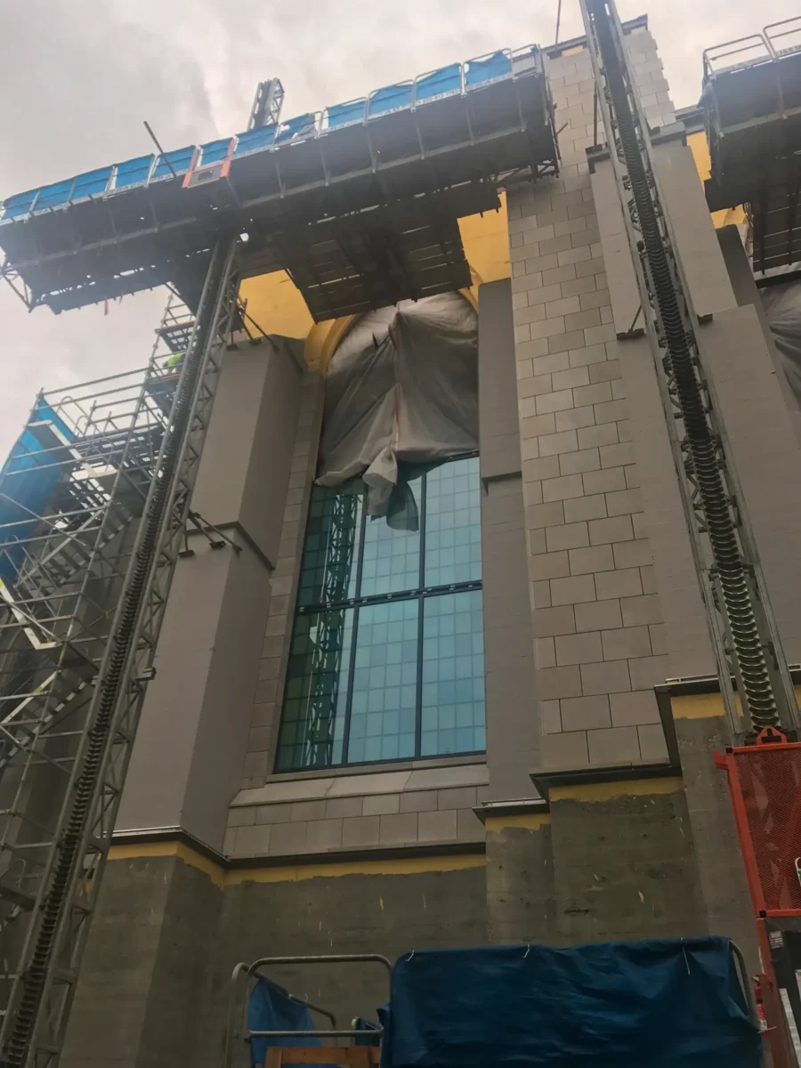 Colored glass panels in the arched windows of St Mark’s Cathedral, and the same panels on the shop floor before installation.