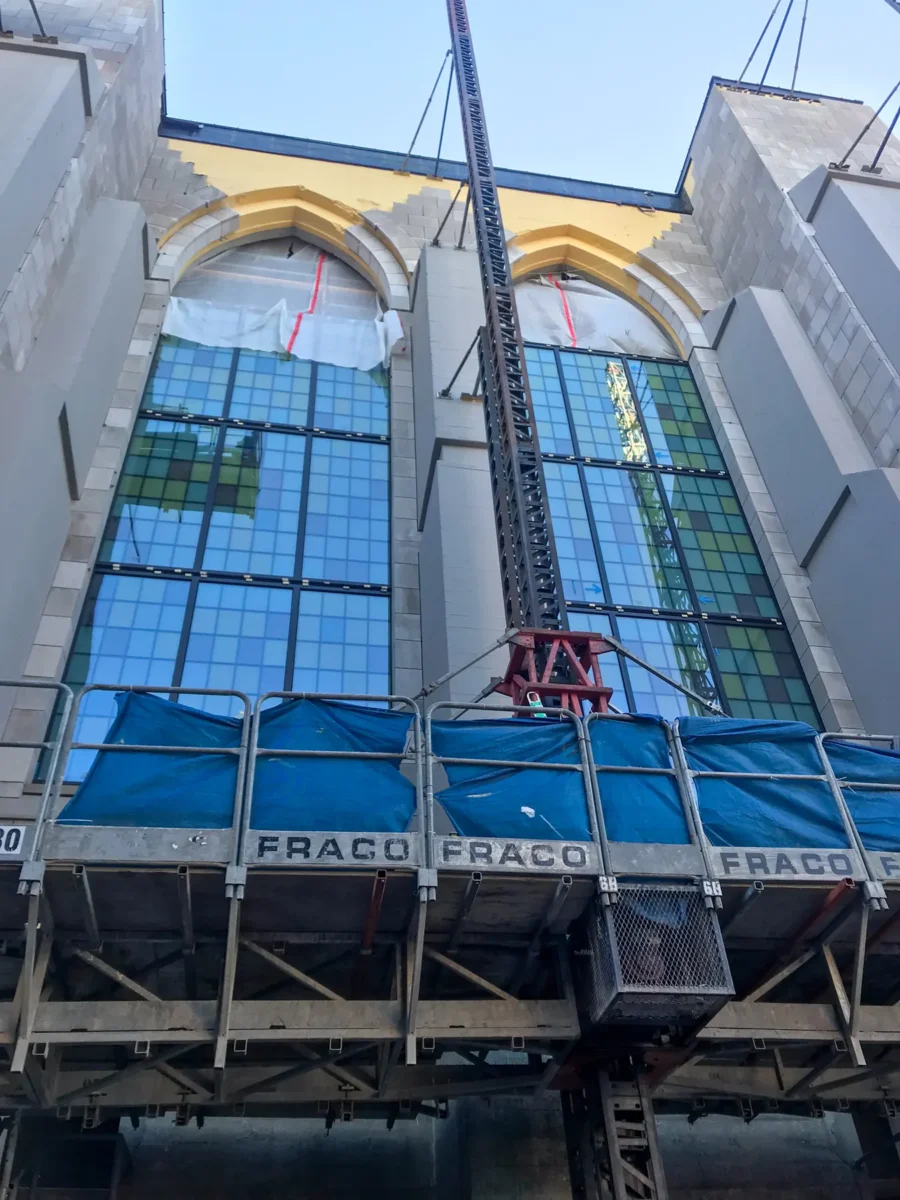 Colored glass panels in the arched windows of St Mark’s Cathedral, and the same panels on the shop floor before installation.