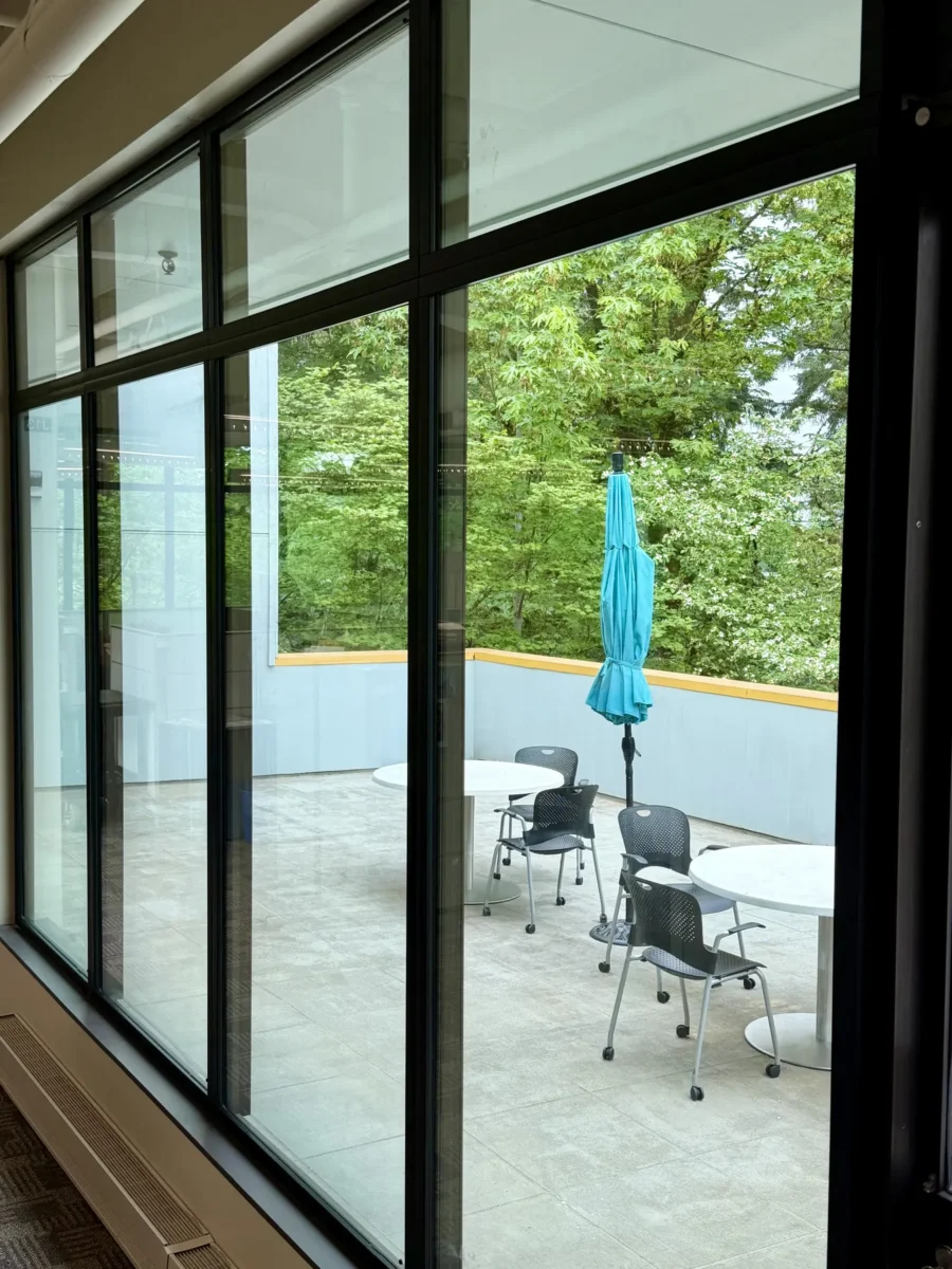 Window and curtain wall work at the Stryker building, with glazed elevations looking onto the trees outside.